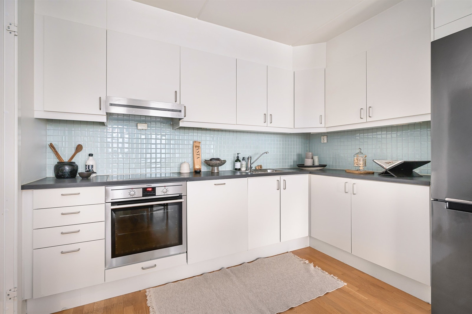 Funksjonelt og lekkert kjøkken. Kjøkkeninnredning er med glatte skapfronter og laminat benkeplater med nedfelt oppvaskkum og et greps armatur. Galleribilde