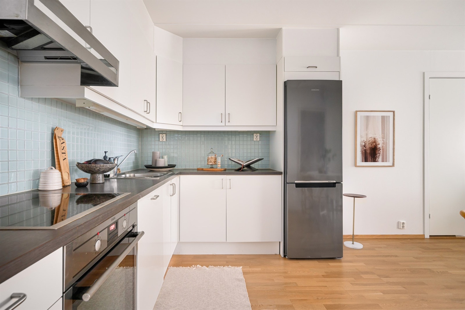 Integrerte hvitevarer som oppvaskmaskin, stekeovn, induksjon koketopp og kjøl-/fryseskap. Montert komfyrvakt. Galleribilde