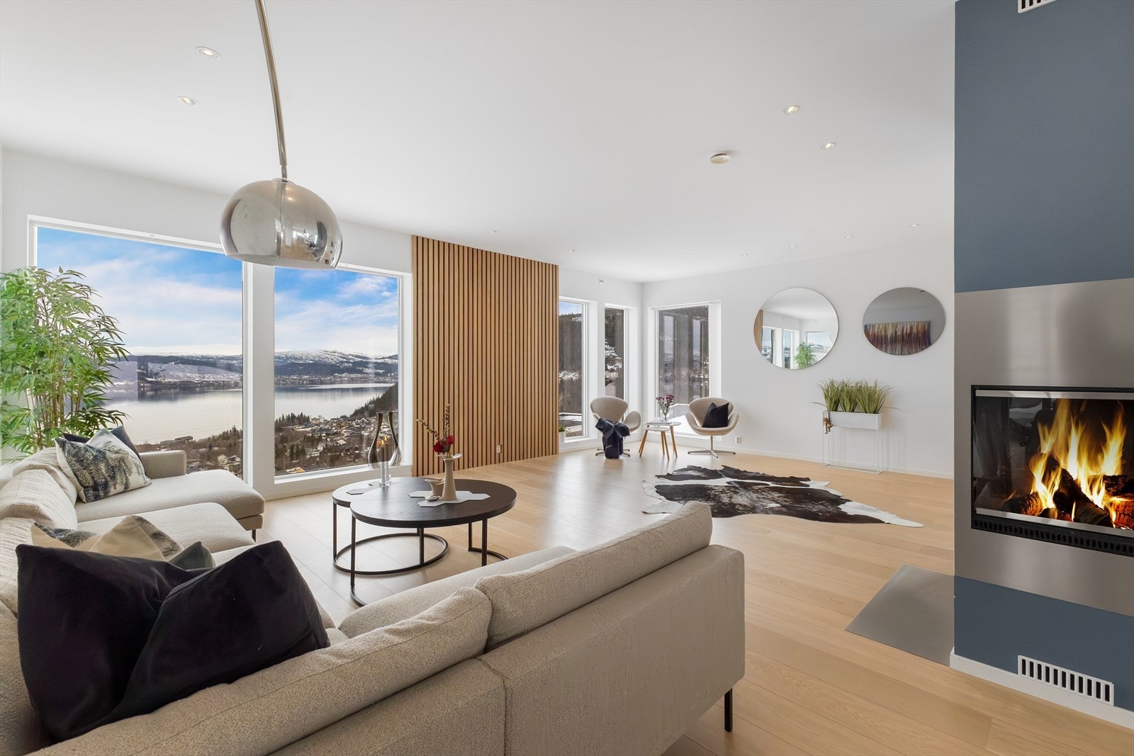 Gulv til/tak vinduer gir en magisk utsikt. Spileveggen skaper en lun kontrast mot den gjennomgående. stilrene utsmykningen av boligen. Galleribilde