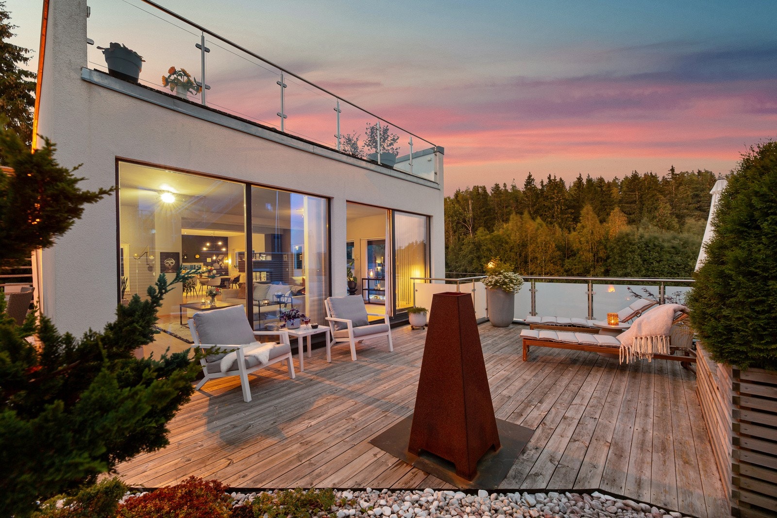 I enden av stuen er det utgang til en stor markterrasse med koselig utepeis og nedgang til hagen. Galleribilde