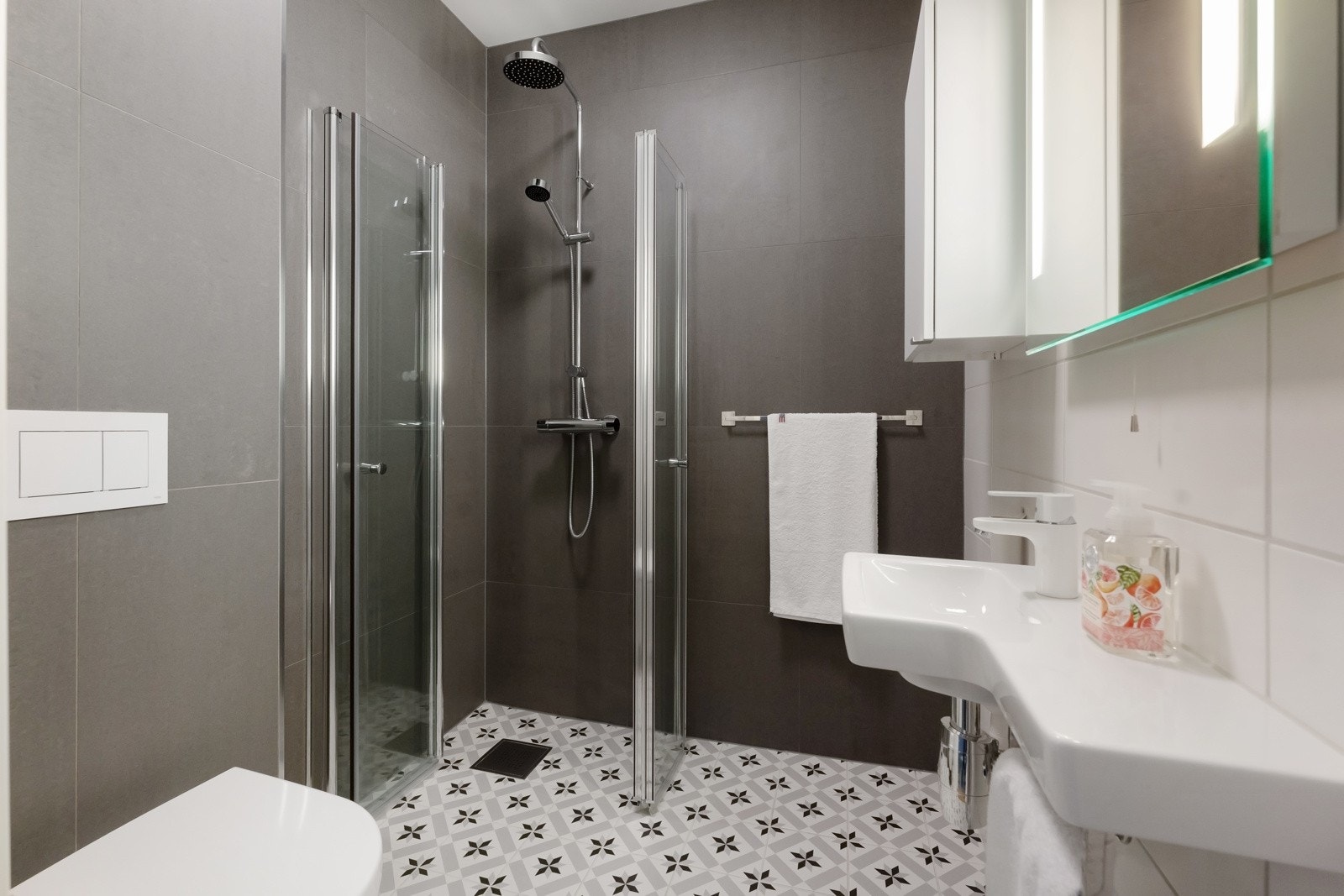 Baderom nr. 2 har servant med speil og integrert LED-belysning, frittstående skap, dusjhjørne, vegghengt toalett og håndkleholder. Galleribilde