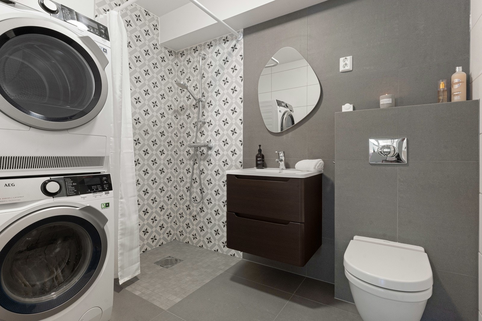 Bad med opplegg for vaskemaskin og tørketrommel, hvor deler av veggene ble oppgradert med flis på flis i 2024. Galleribilde