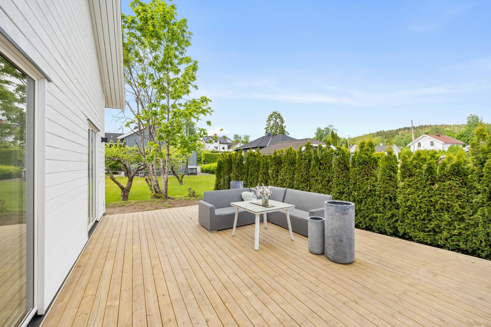 Terrasse på baksiden av huset med skjermende hekk. Galleribilde