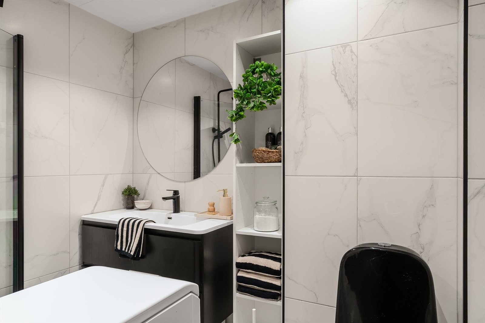 Badet er flislagt med gulvvarme, dusjløsning og plass til vaskemaskin. Galleribilde