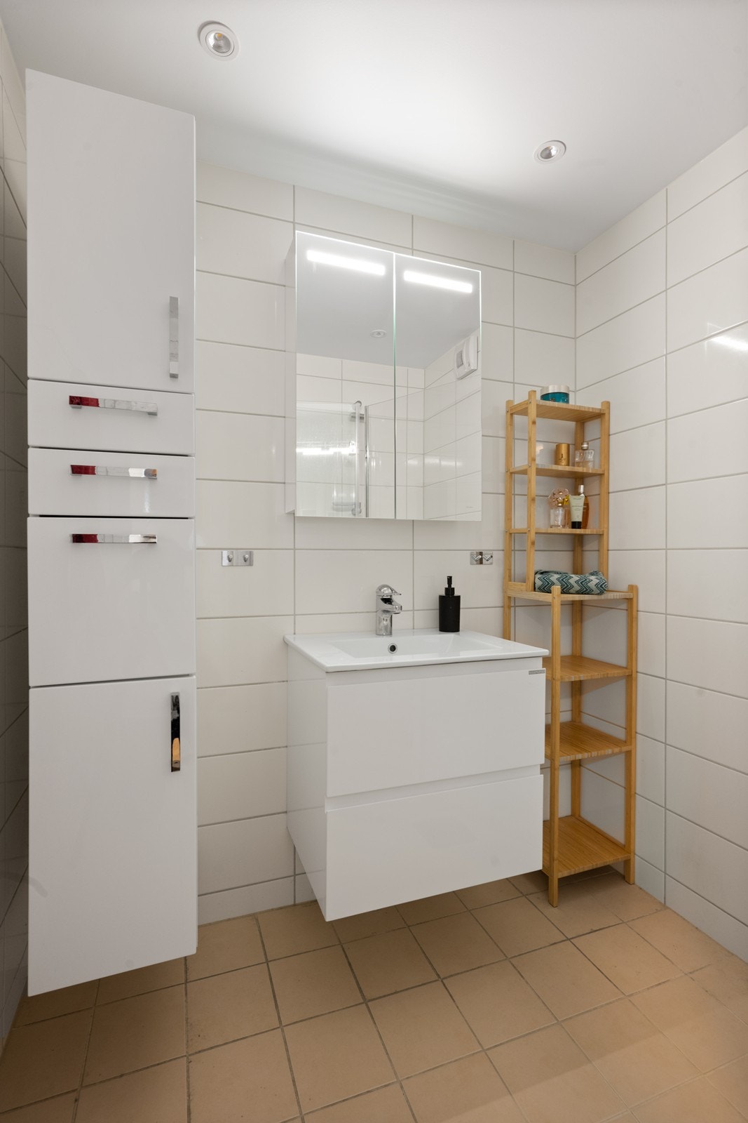 Badet ble oppgradert i 2019 i regi av borettslaget, inkludert utskifting av rørstammer. Rommet fremstår moderne med flislagte overflater - beige fliser på gulv og hvite på vegger - samt slett tak med innfelte spotter som gir god belysning. Galleribilde