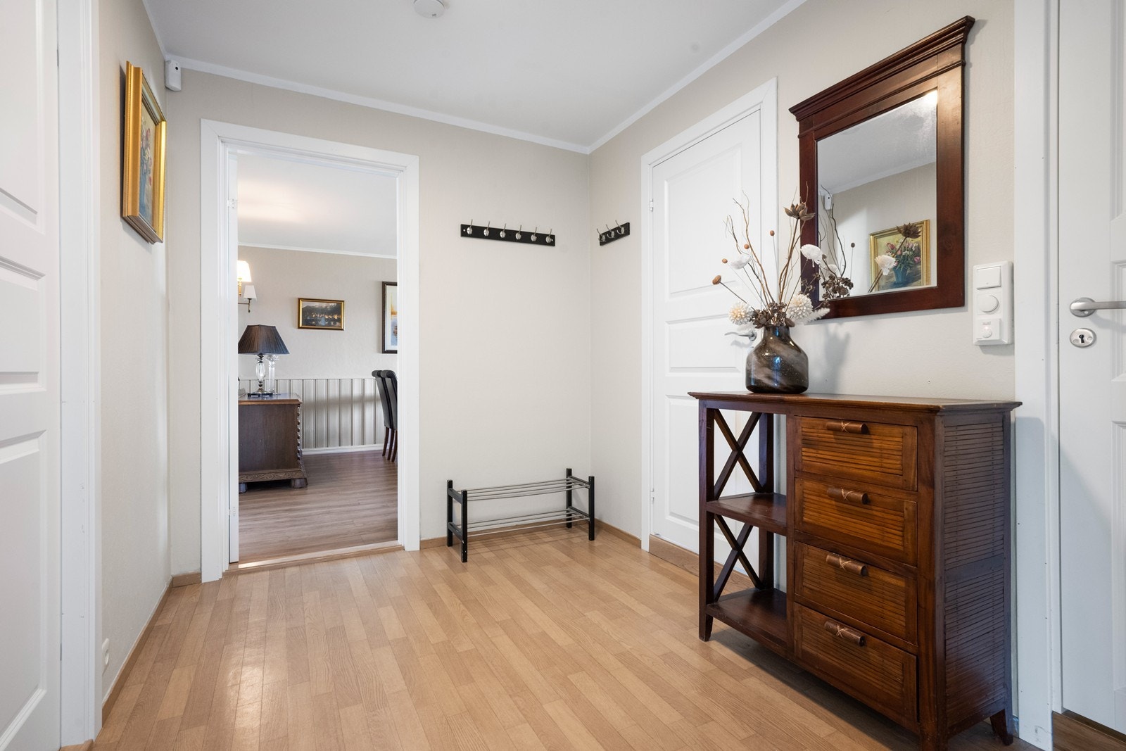 Boligen har en romslig gang med god plass til å henge fra seg yttertøy og sette fra seg sko. Her møtes du av en praktisk og innbydende entré som gir et godt førsteinntrykk og fungerer som et naturlig knutepunkt mellom boligens ulike rom. Galleribilde