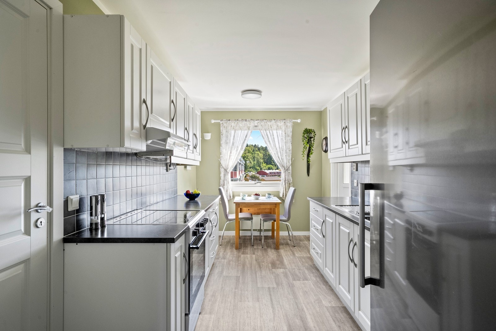 Kjøkkenet er utstyrt med frittstående komfyr, oppvaskmaskin og kjøleskap som medfølger salget, uten noen form for garanti utover evt. resterende leverandørgaranti. Galleribilde