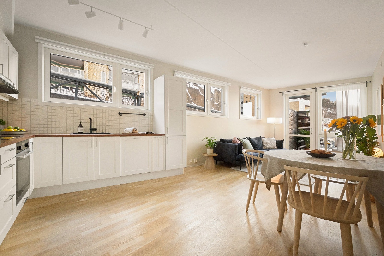 Lyst og funksjonelt kjøkken med god arbeidsplass på benk og oppbevaringsplass i skuffer og skap. Galleribilde