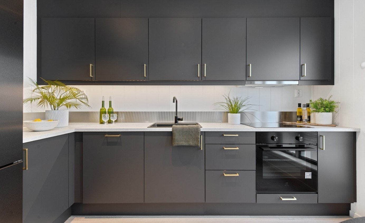 Moderne kjøkken med integrert stekeovn, oppvaskmaskin og induksjonstopp. Plass til kombiskap. Galleribilde