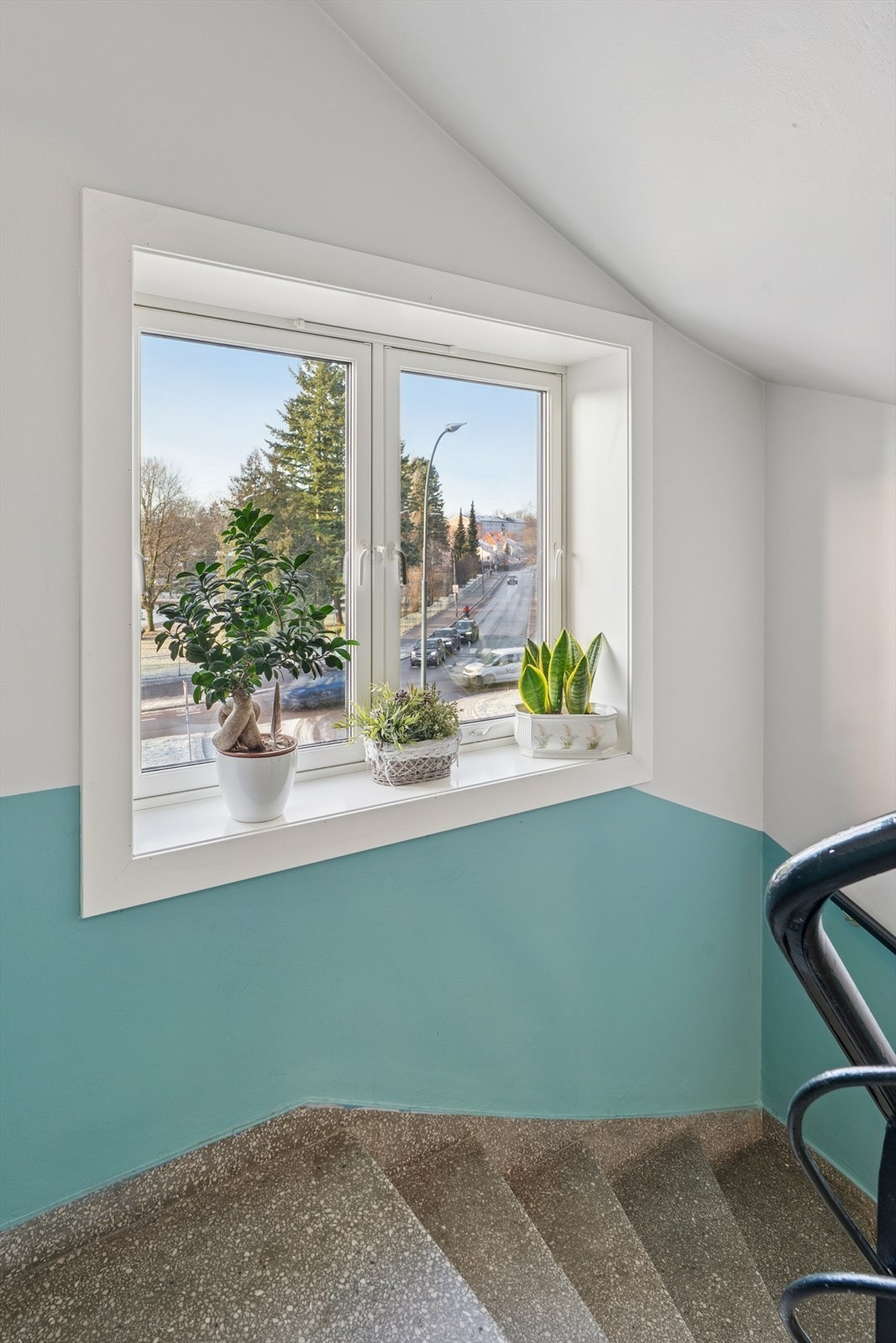 Pent opparbeidet trappoppgang med vindu og grønne innslag. Galleribilde