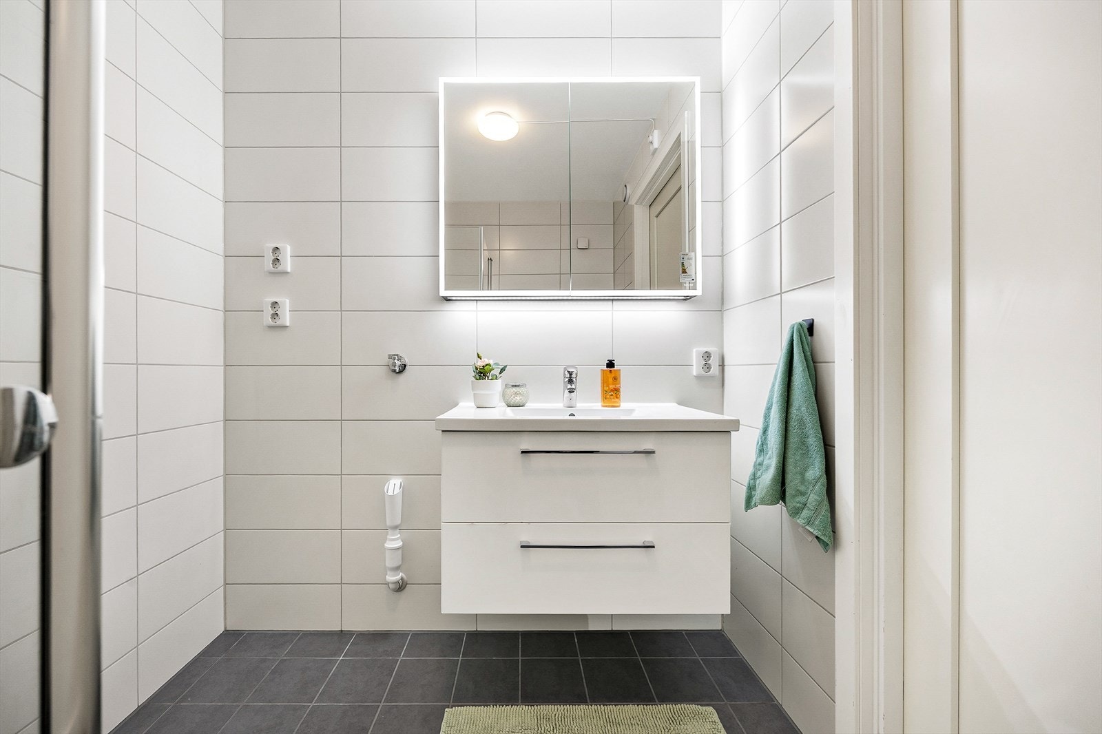 Innredningen har heldekkende servant over skuffeseksjon og et dobbelt speilskap med integrert belysning. Galleribilde