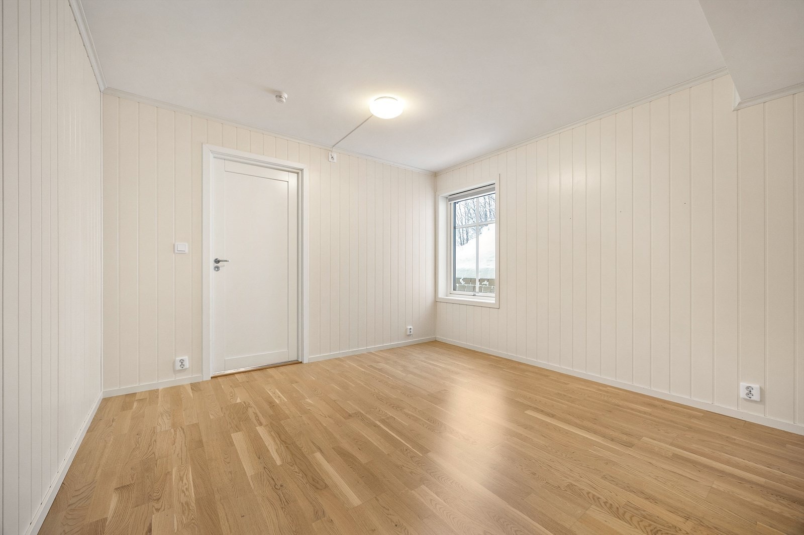 Begge er holdt i en stilren kombinasjon med lysmalte panelvegger mot gyllent parkettgulv. Galleribilde