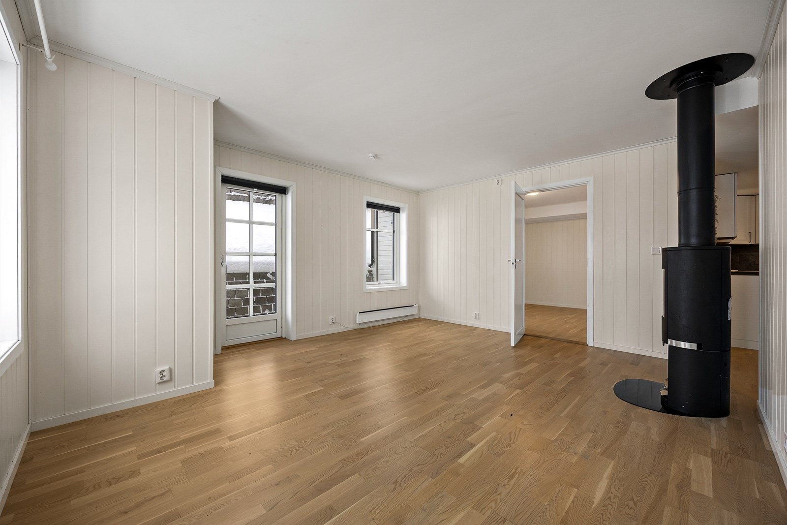 På veggene er det lysmalt panel, som står godt til det gyldne parkettgulvet. Galleribilde