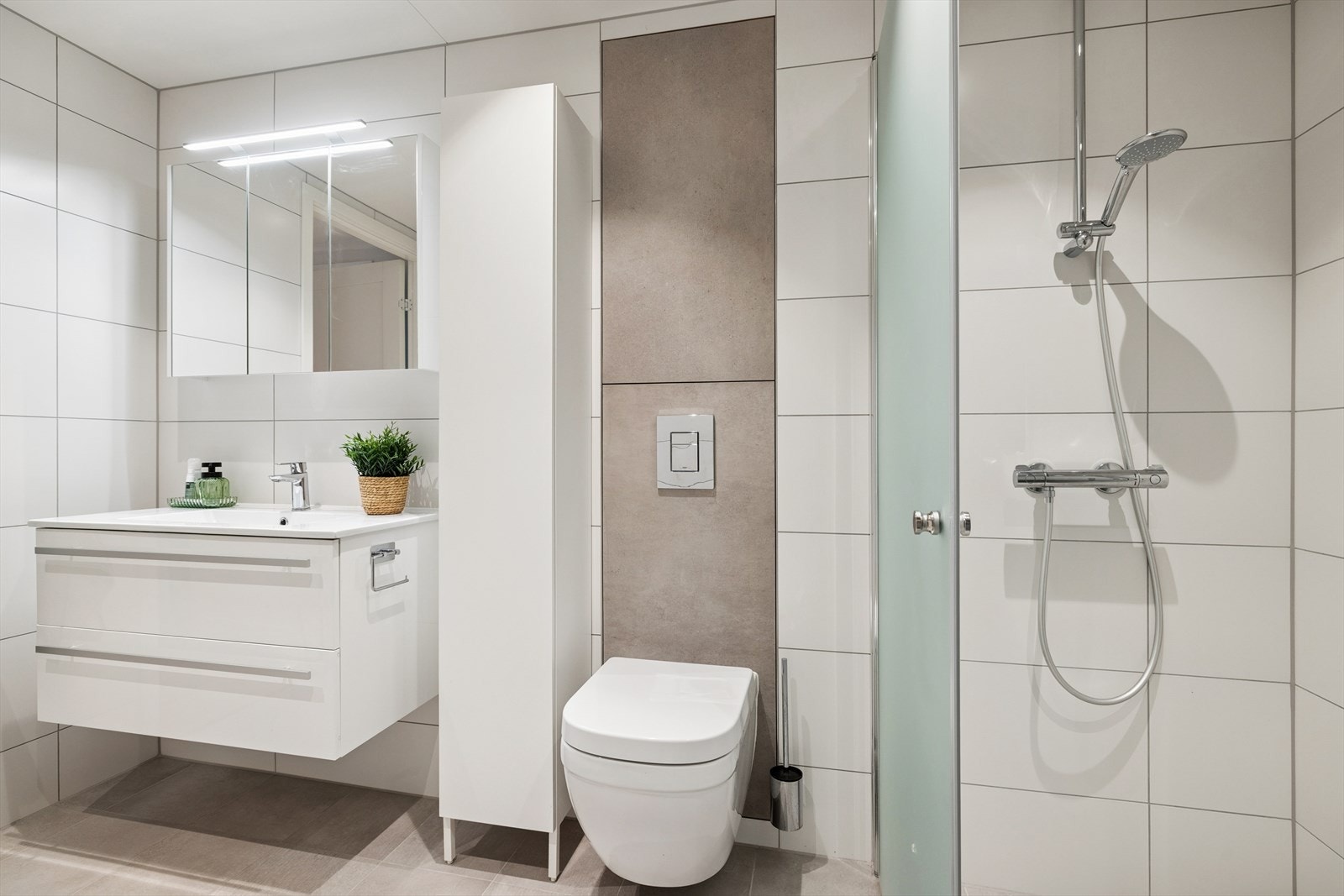 Lyst og moderne bad med stilrene detaljer og god plass til hverdagskomfort Galleribilde