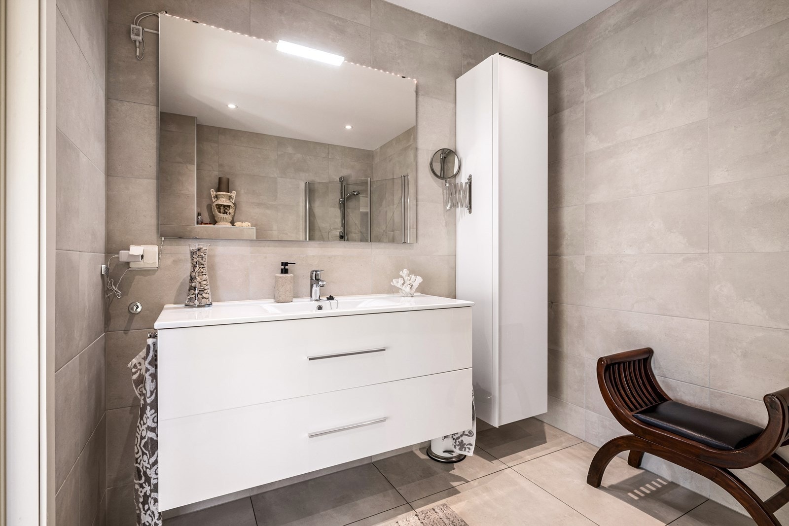 Badet har gode oppbevaringsløsninger og nedfelt servant med innredning. Galleribilde