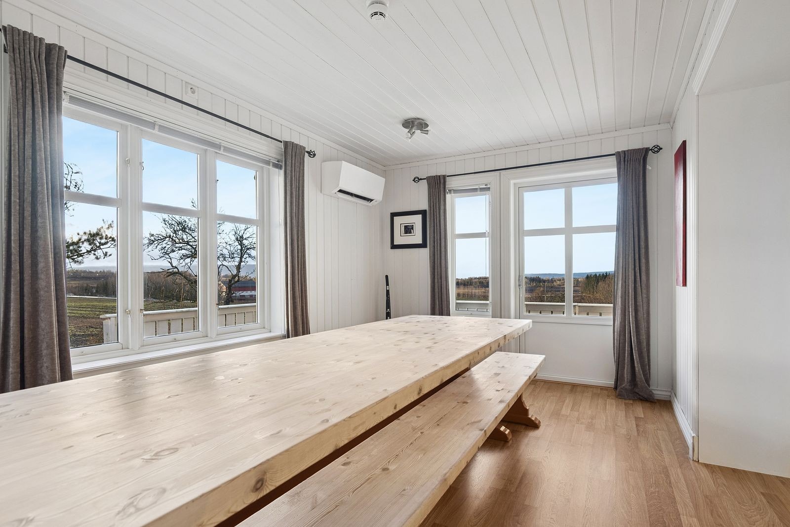 Spiseområde i tilknytning kjøkkenet med dør ut til verandaen. Varmepumpe på veggen. Galleribilde