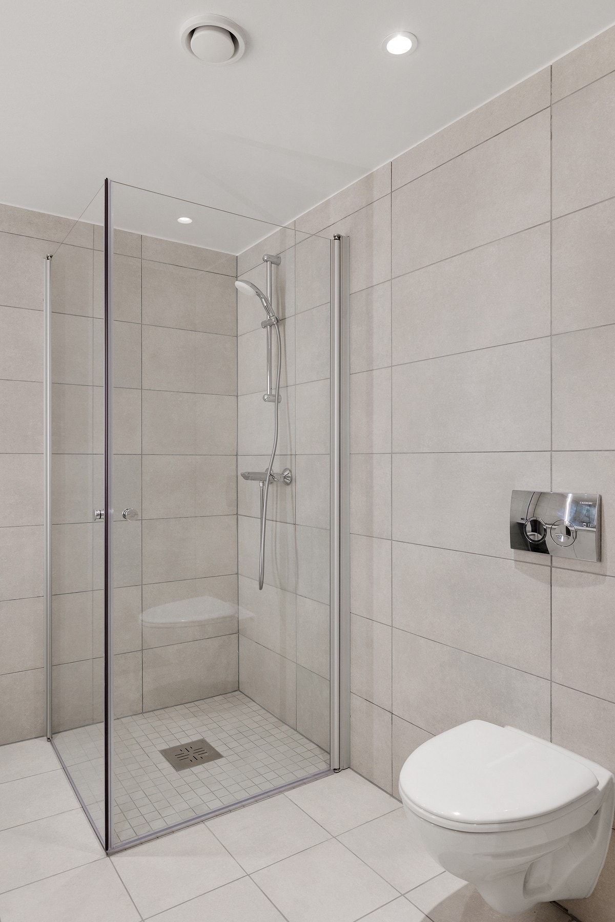 Badet har dusjhjørne med innfellbare glassvegger, samt vegghengt toalett med softclose sete og krom spyleknapp gir badet et moderne og funksjonelt preg. Galleribilde