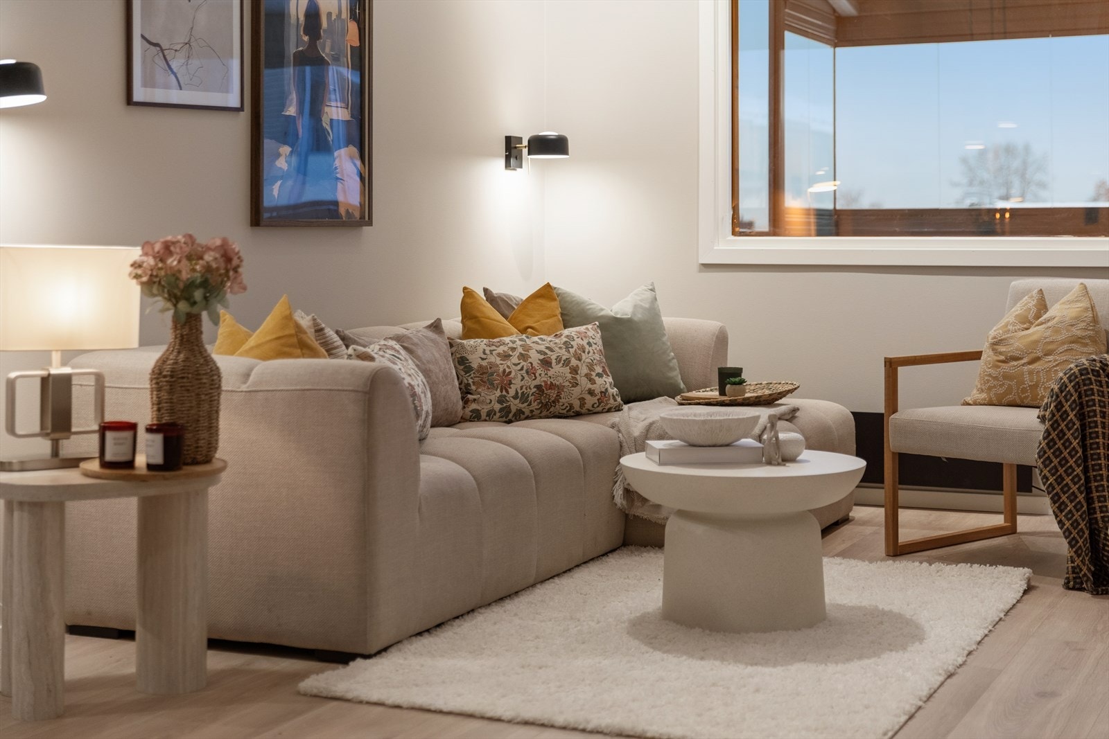 En romslig og åpen stue med store vinduer som slipper inn rikelig med dagslys og skaper en luftig atmosfære. Galleribilde