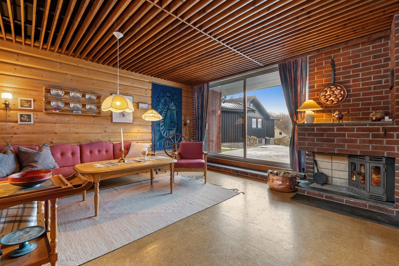 På den ene veggen er det en peis i teglstein med innsats som fungerer som et blikkfang og bidrar til både varme og atmosfære. Galleribilde