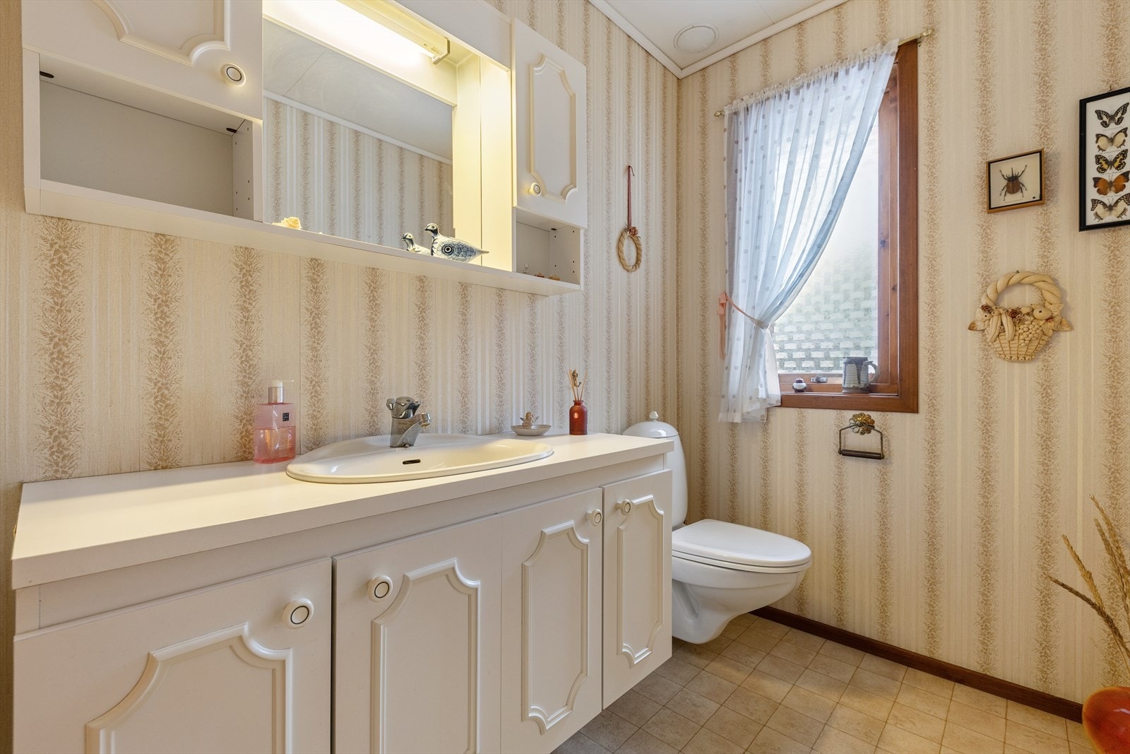 Separat toalettrom utstyrt med en innredning med nedfelt servant og vegghengt toalett. Galleribilde