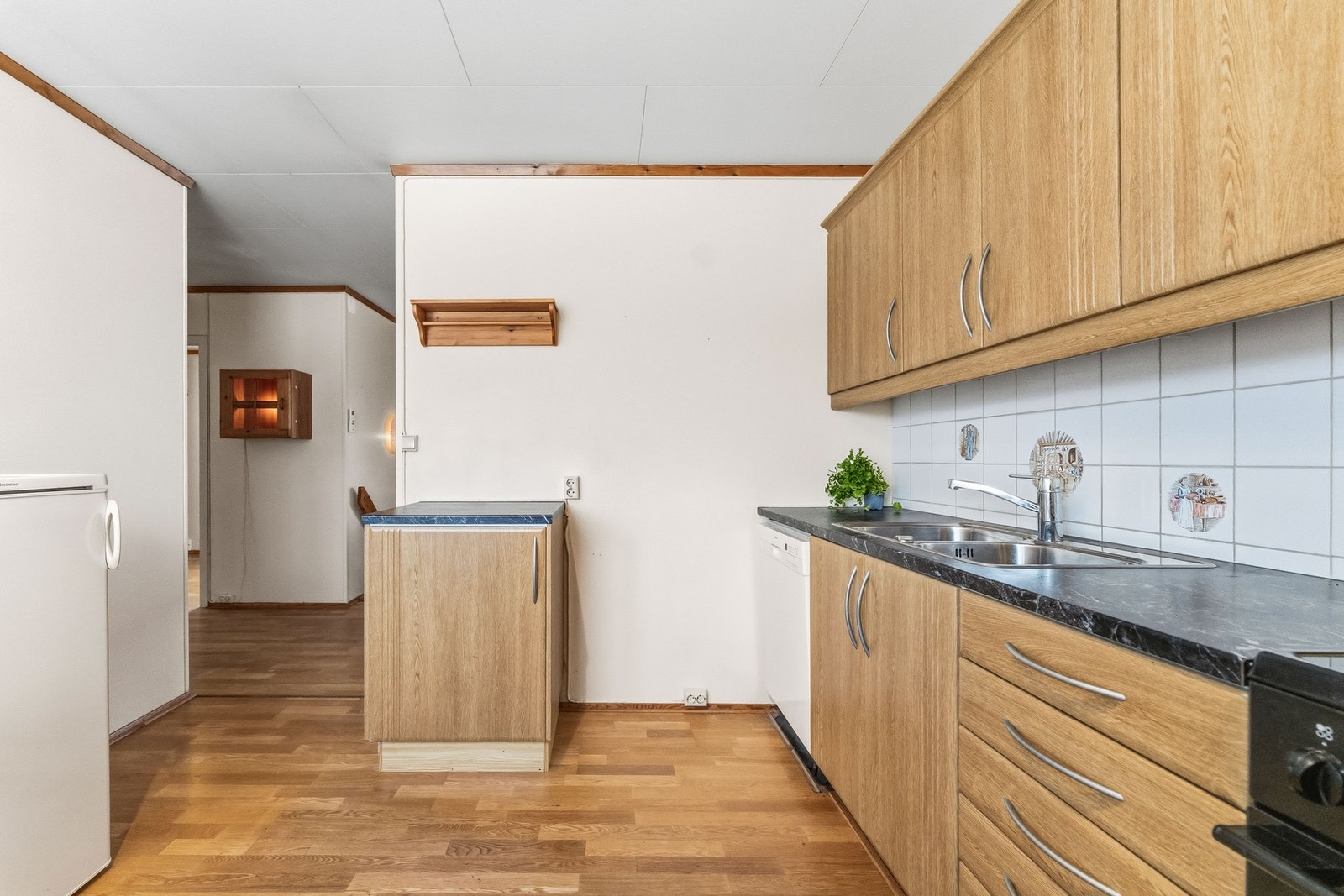 Kjøkkeninnredning med laminerte skrog, glatte fronter og laminert benkeplate med kjøkkenkum. Galleribilde