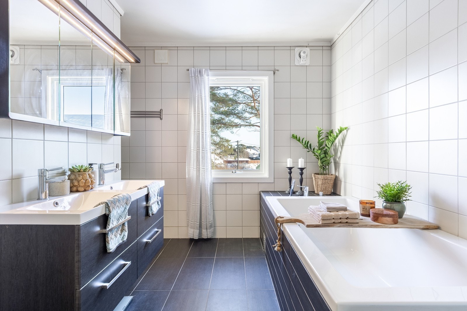 Flislagt bad med dusjnisje, dobbel servant og innfliset badekar. Galleribilde