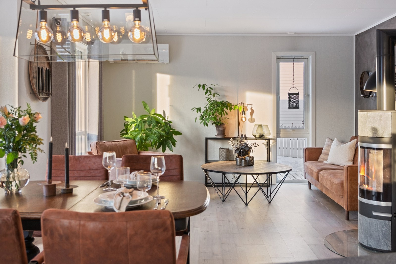 Stue med store vindusflater, varmepumpe og vedovn som gir lun atmosfære. Galleribilde