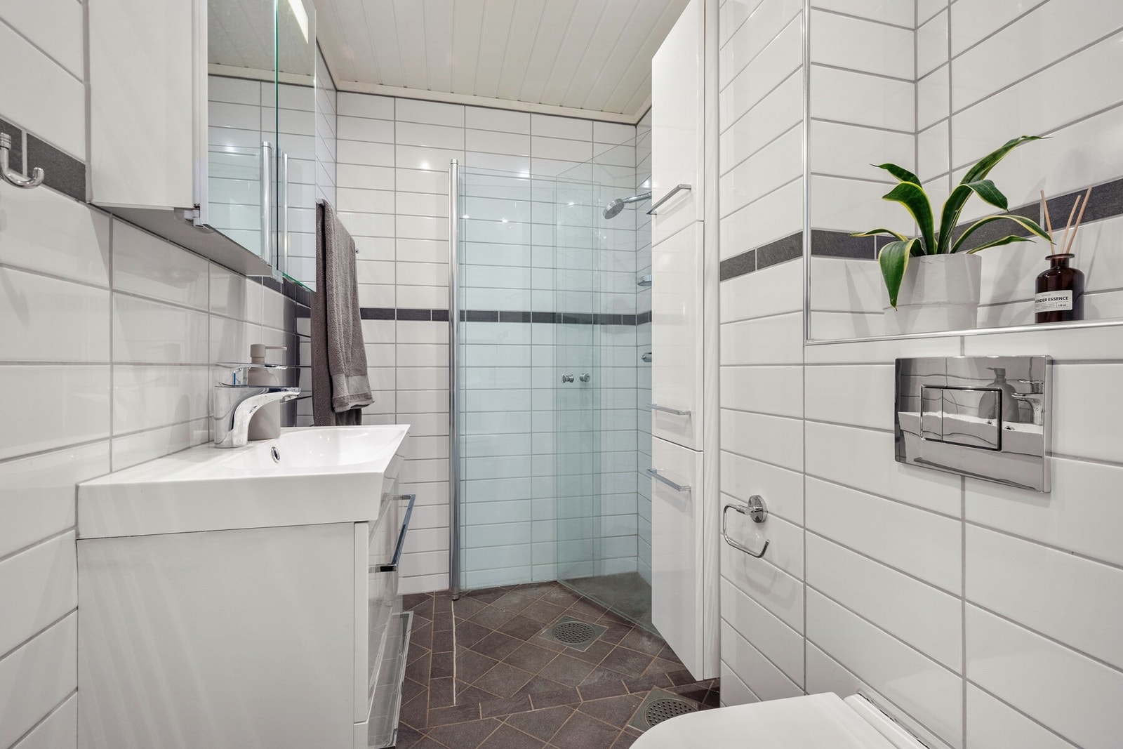 Badet er moderne og innbydende, og har en stilren utførelse med flislagte vegger og gulv samt behagelig gulvvarme. Galleribilde