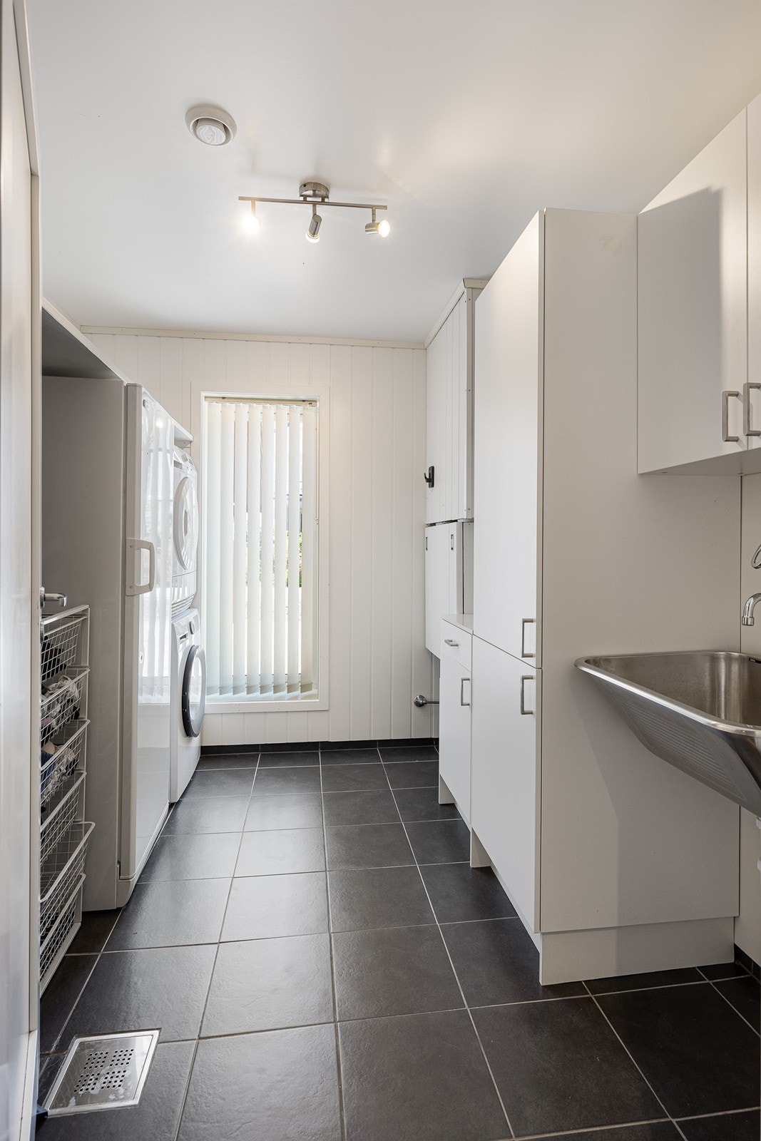 Vaskerommet har flere skap, vaskekum i stål og nisje til vaskesøyle. Galleribilde