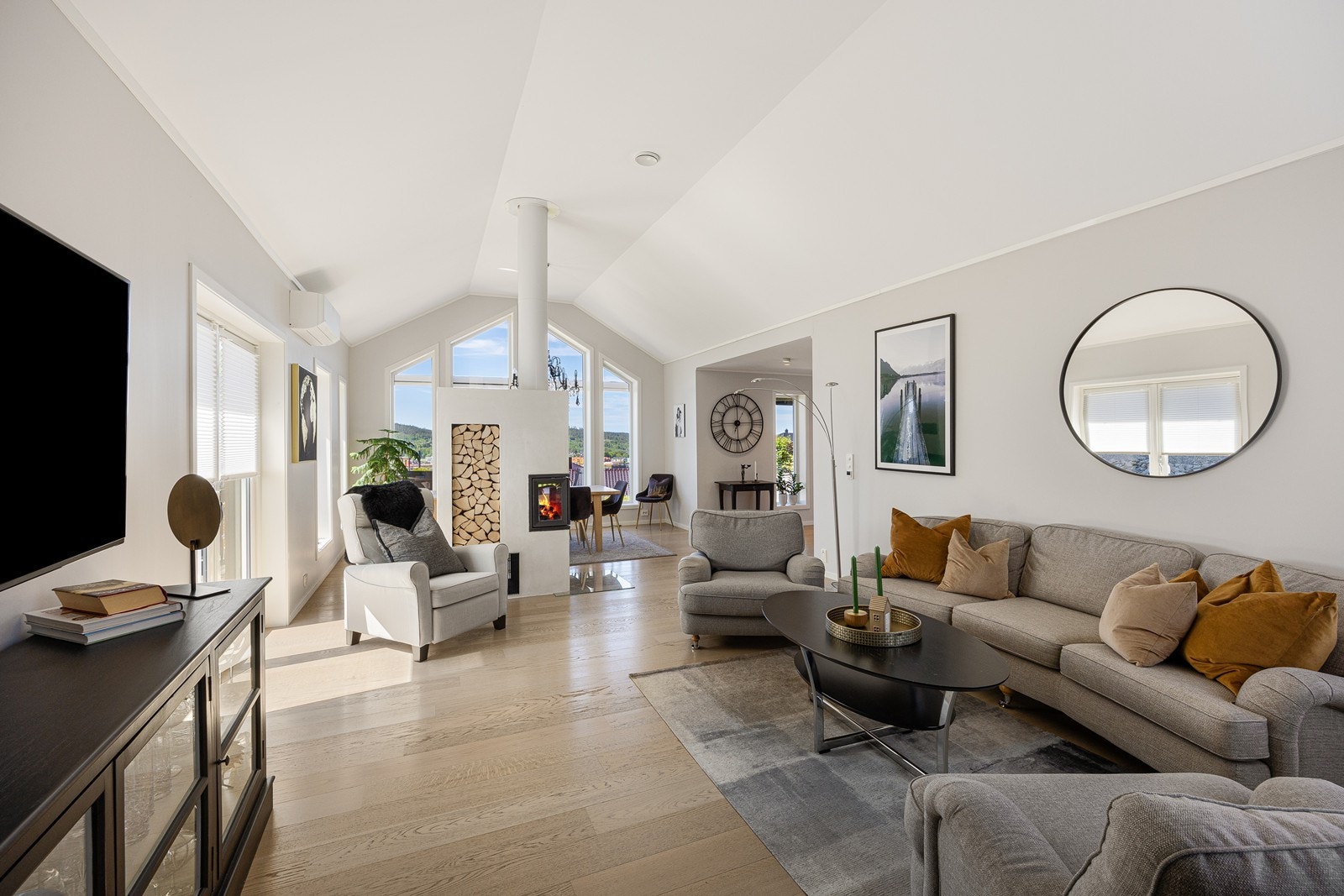 Stuen bades i dagslys fra gode vindusflater på tre sider, inkludert tofløyede dører ut til terrassen og høye mønevinduer. Galleribilde