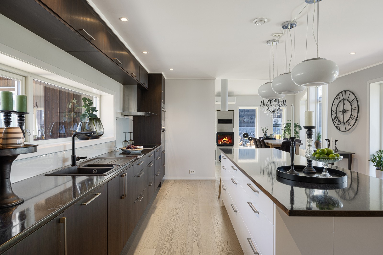 Frontene er mørke og glatte med trestruktur og benkeplaten er i tynn, sort laminat med vaskekum i kompositt. Kjøkkenøya har samme benkeplate, men hvite, glatte skap- og skuffefronter. Galleribilde