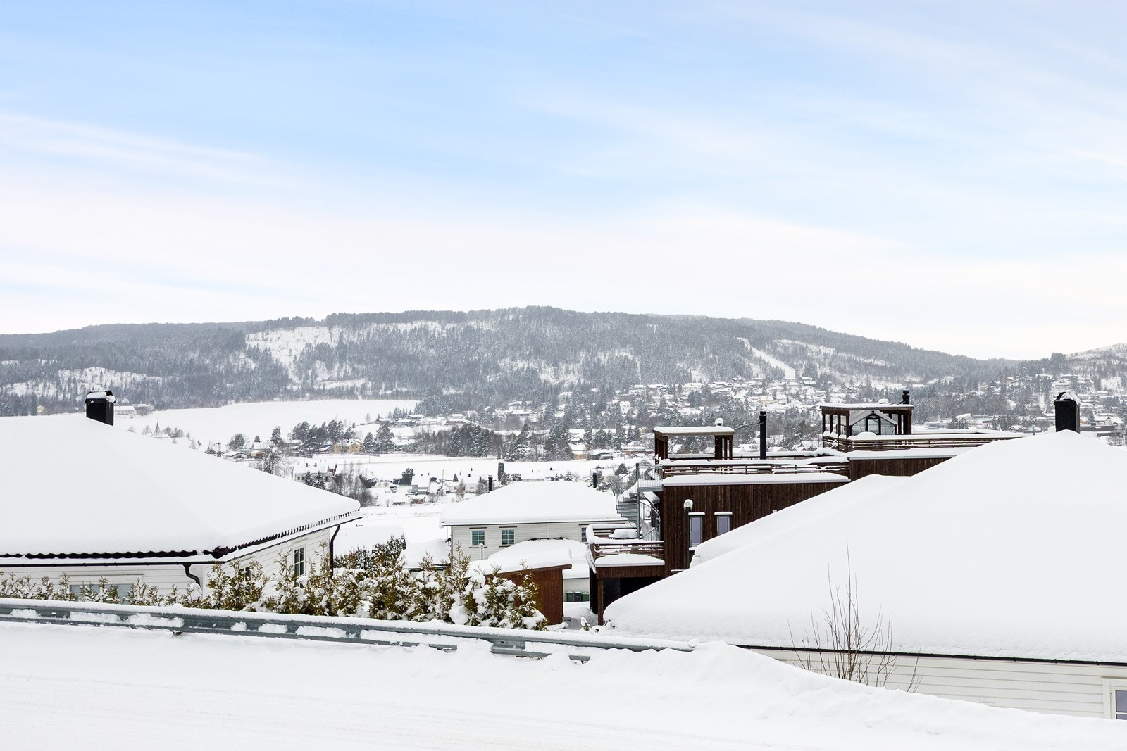 Boligen omkranses av en stor, nordvestvendt terrasse. Utsikten strekker seg vidt over området, til de grønne åsene i horisonten. Galleribilde