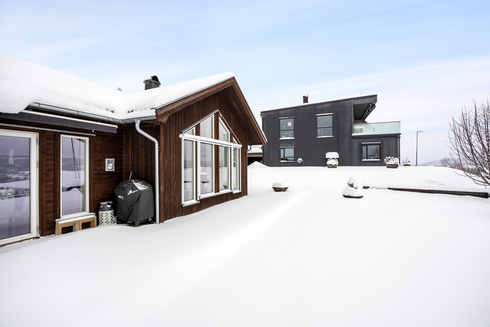 Uteplassene har dekke av terrassebord og begge sider skjermes av markise utenfor midtdelen. Galleribilde