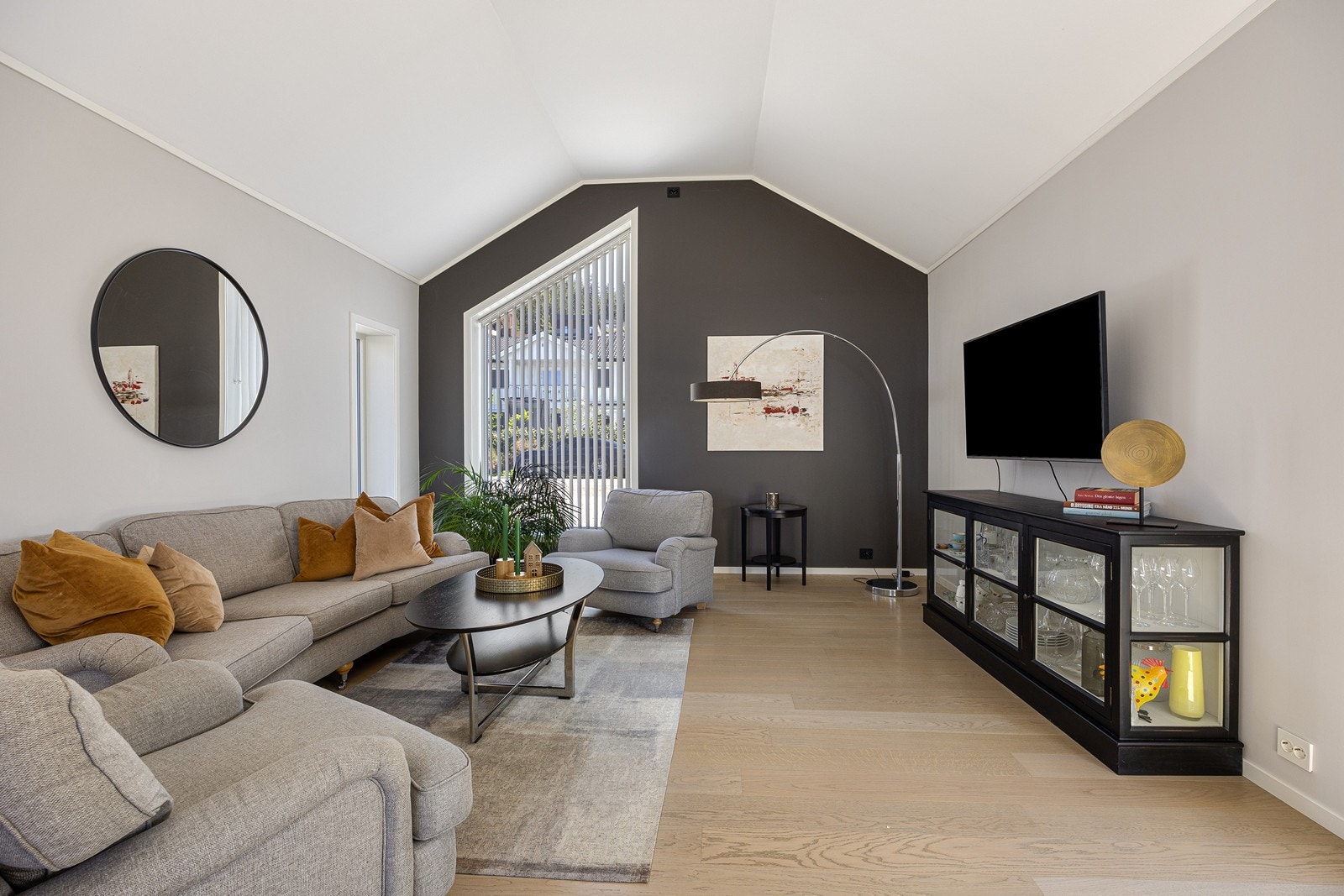 Stuen har enstavs parkettgulv som er lagt sømløst inn i kjøkken og gang, samt hvitmalt himling og lysmalte veggflater med én mørk fondvegg. Galleribilde