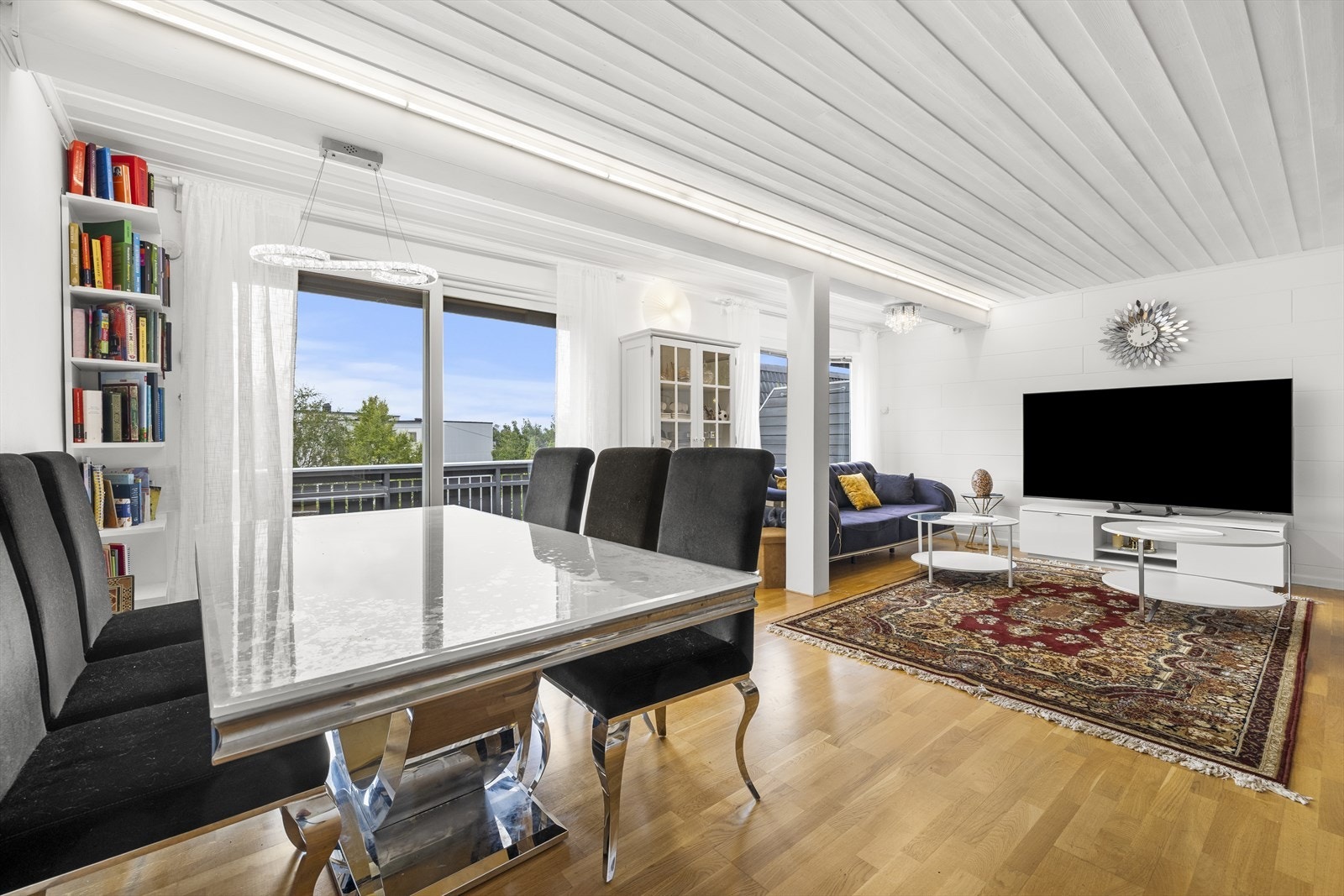 Romslig stue med parkettgulv og panel i taket. Galleribilde