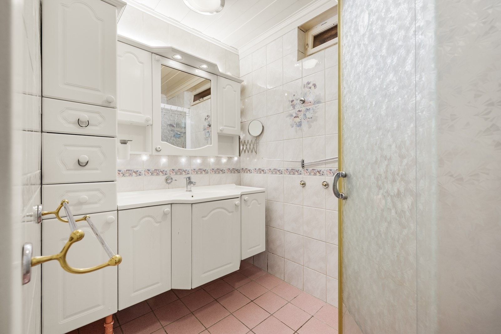 Flislagt bad med elektriske varmekabler i gulvet, dusjhjørne og heldekkende servant med under- og overskap. Galleribilde