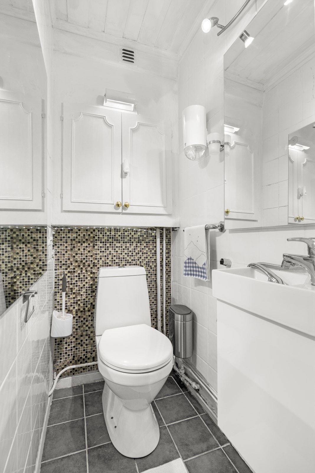 Separat og flislagt toalettrom i underetasjen innredet med toalett og heldekkende servant. Galleribilde