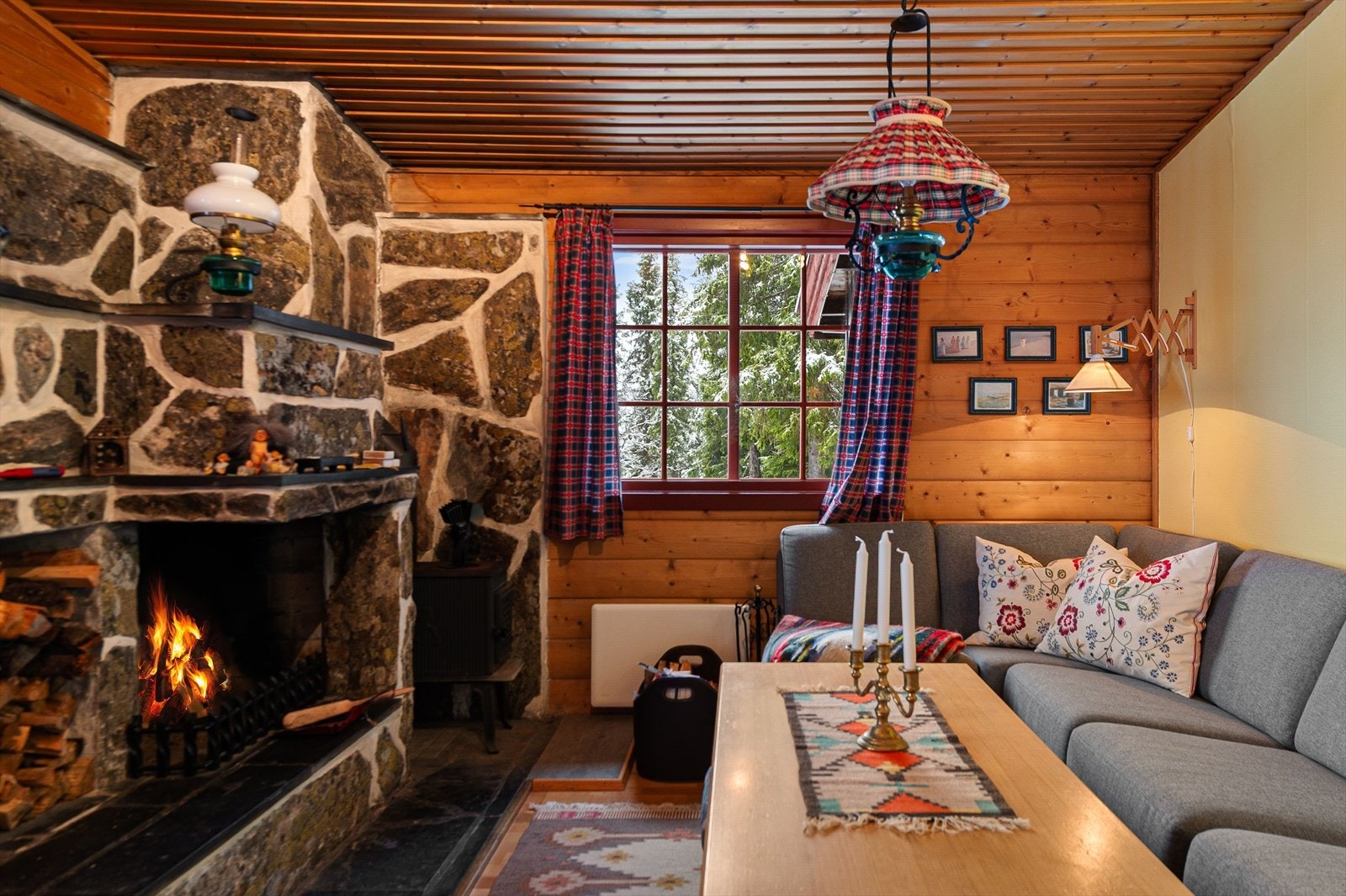 Store vinduer gir rikelig med naturlig lys inn i stuen, som har panelvegger og tak (kilde: tilstandsrapport). Galleribilde