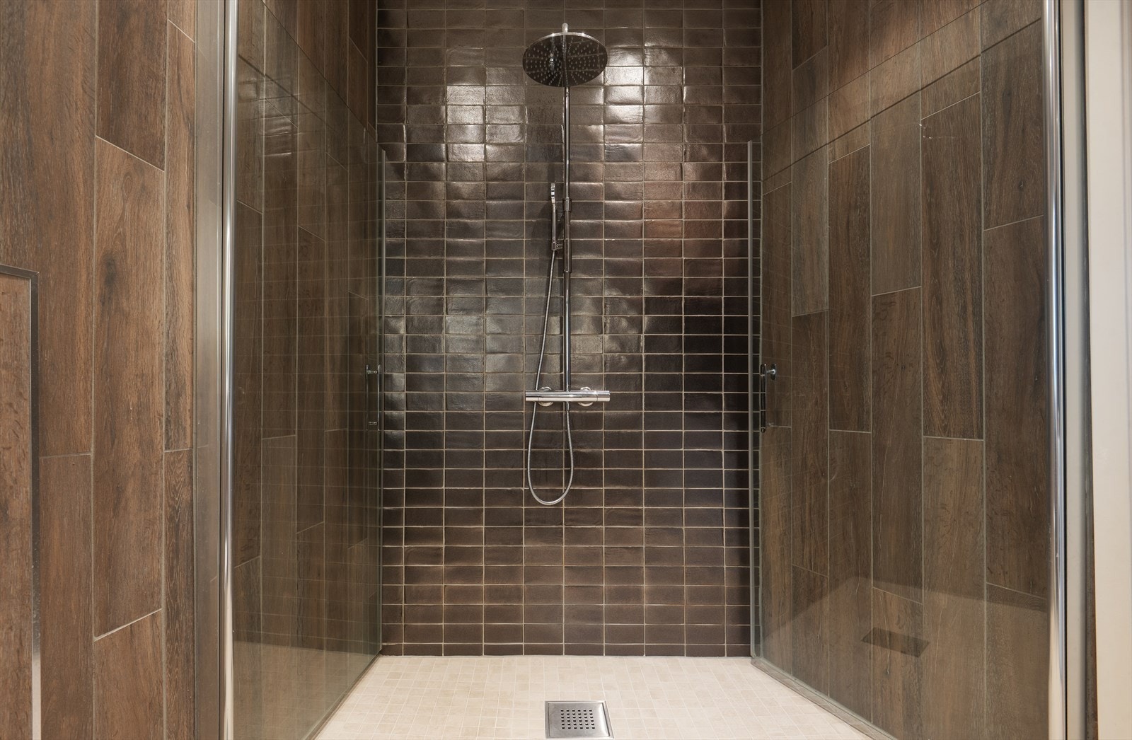 Badet har veggmontert toalett med innebygd sisterne, dusj med innfellbare dører i herdet glass. Det er opplegg for vaskemaskin Galleribilde