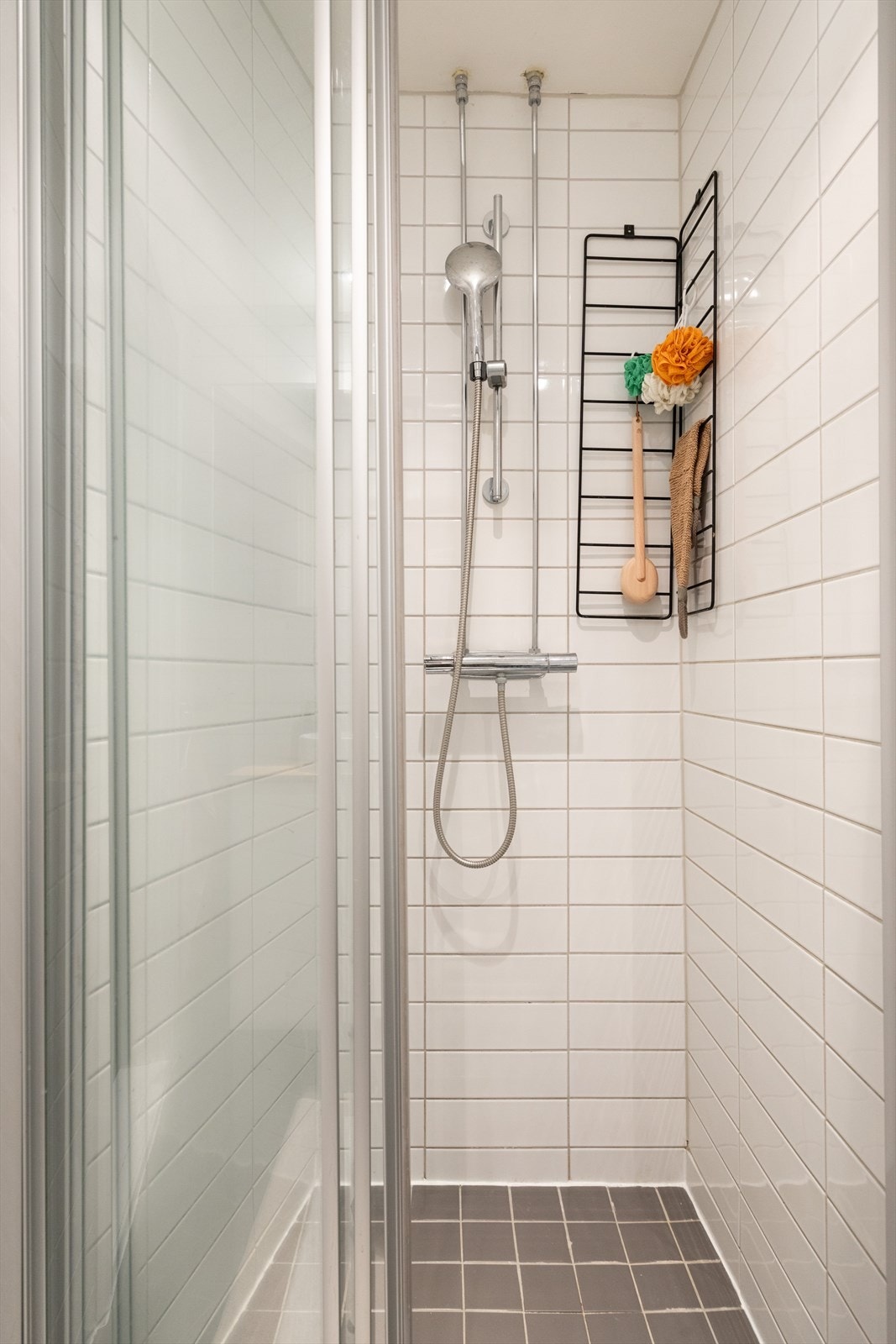 Badet er innredet med vegghengt klosett, baderomsinnredning med servant, speilskap og dusjvegg. Galleribilde