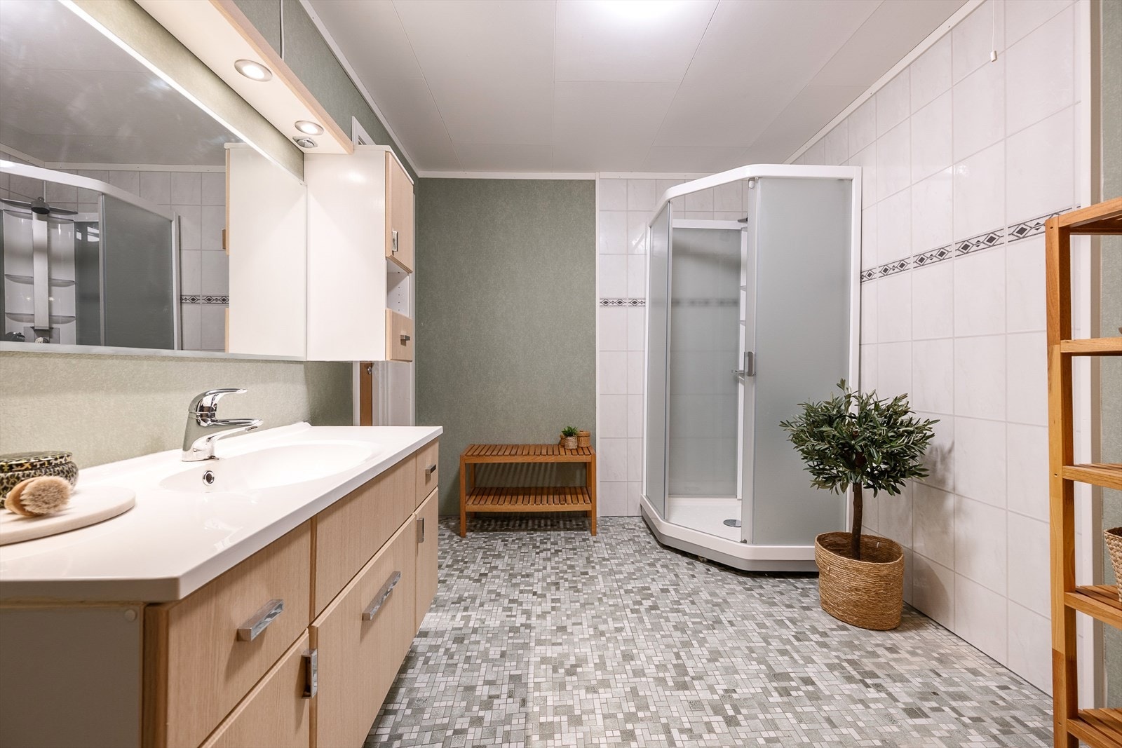 Badet i underetasjen har flislagt gulv med gulvvarme og dusjkabinett. Galleribilde