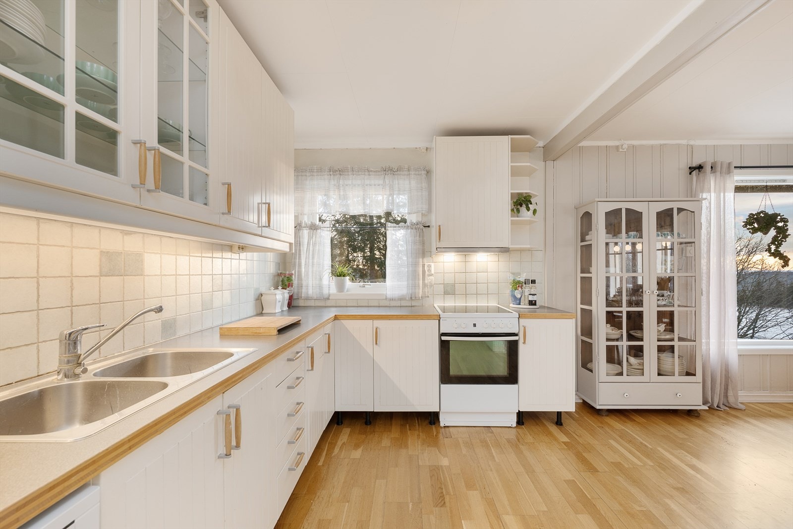 Benkeplaten i laminat har nedfelt stålvask og fliser på veggen over. Galleribilde