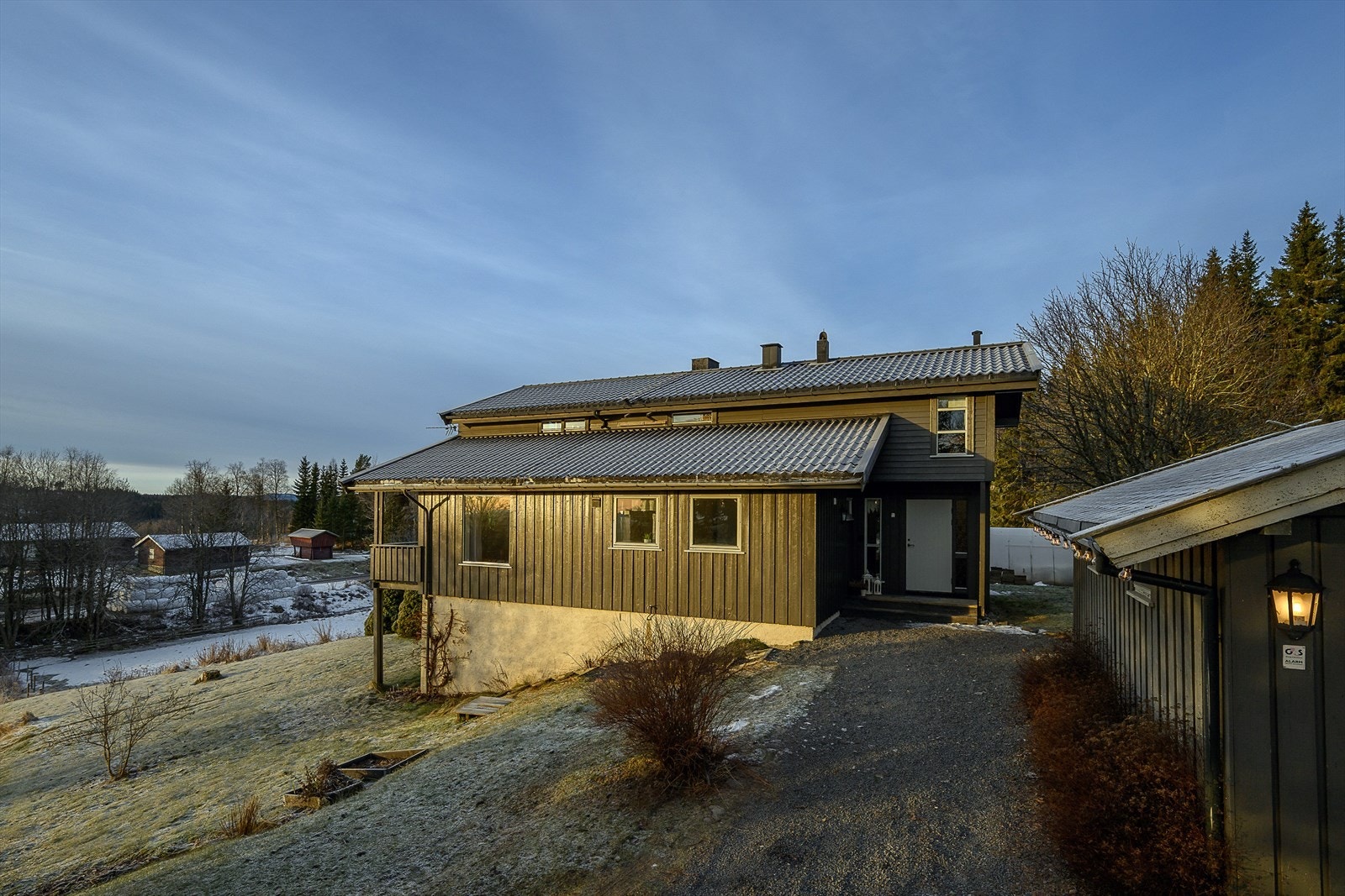 Eneboligen har en fin plassering på tomten med adkomst via gruset innkjørsel. Galleribilde