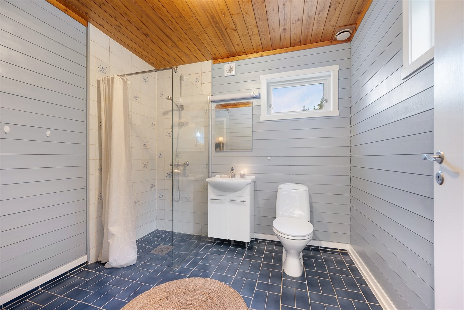 Badet i første etasje har flislagt dusjsone og panel på øvrige vegger. Galleribilde