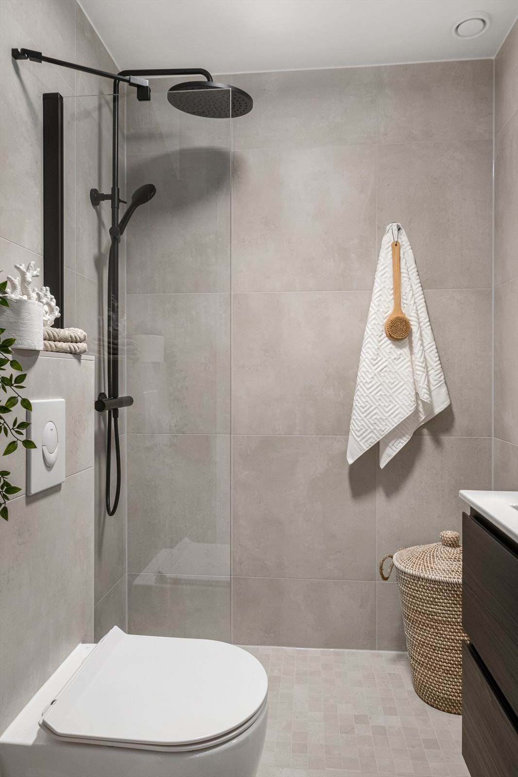 Baderommet er innredet med vegghengt klosett, servant nedfelt i innredning og dusjhjørne med glassfelt. Naturlig avtrekk. Galleribilde