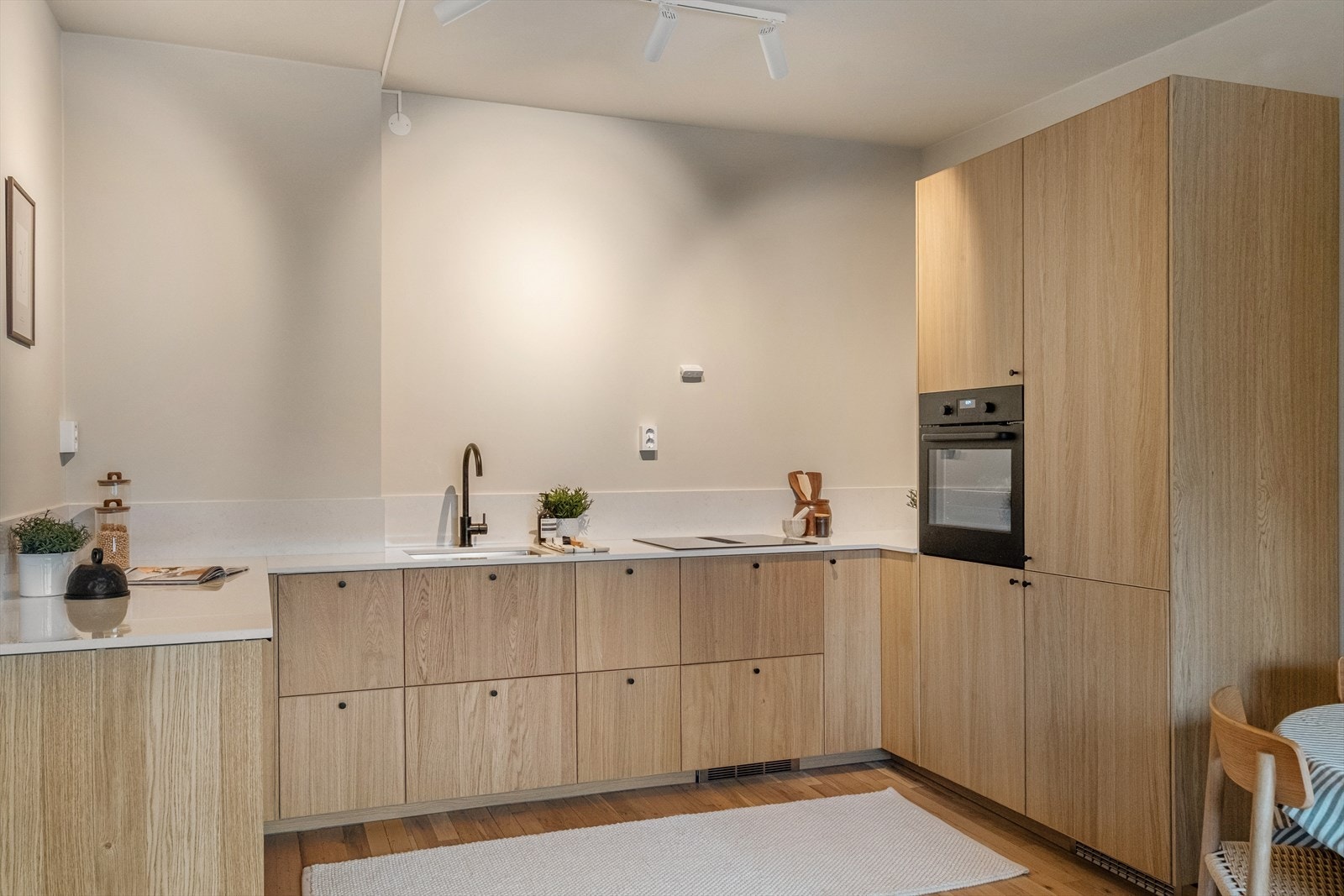 Kjøkkeninnredning med glatte fronter og benkeplate av kompositt med underlimt vask. Galleribilde