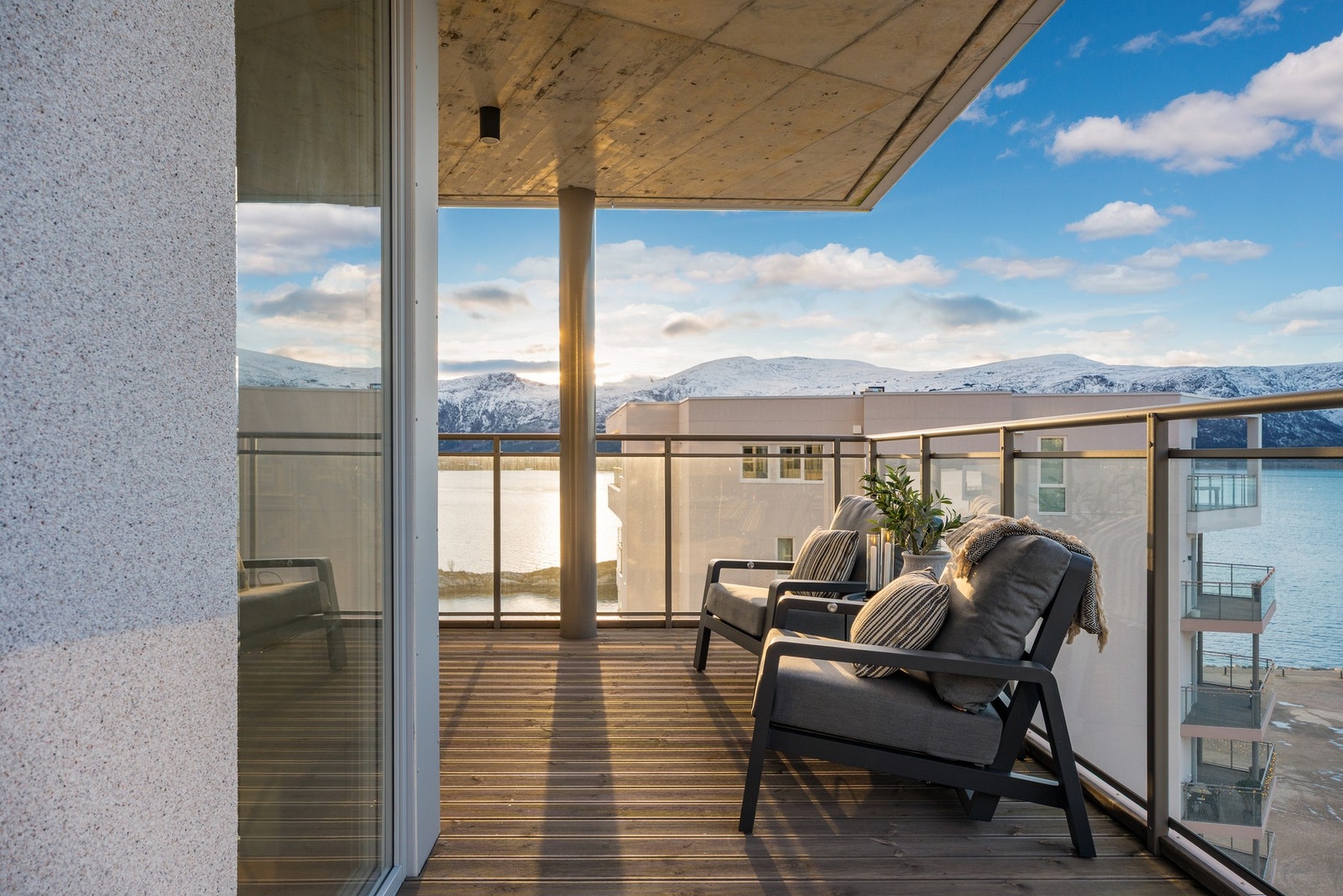 Veranda med utsikt mot fjord, fjell og by, samt til kyststien, badeplasser, lekeområder og grøntareal. Galleribilde