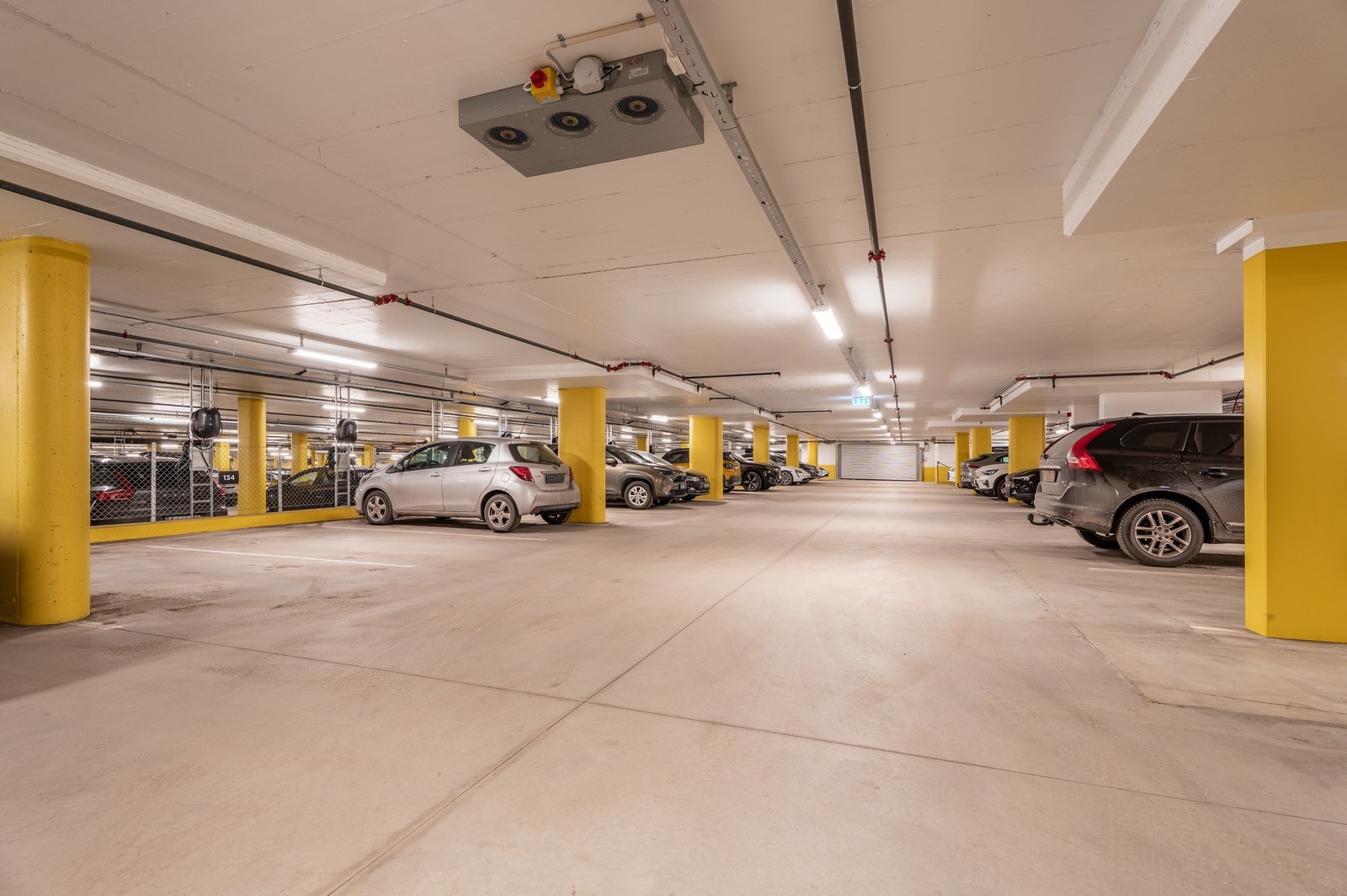 Garasjeanlegg. Parkeringsplass med elbillader like ved heisen (nummer 134). Bod i tilknytning til garasjeanlegget, ikke avbildet. Det vil være tilgang til boden på visning. Galleribilde