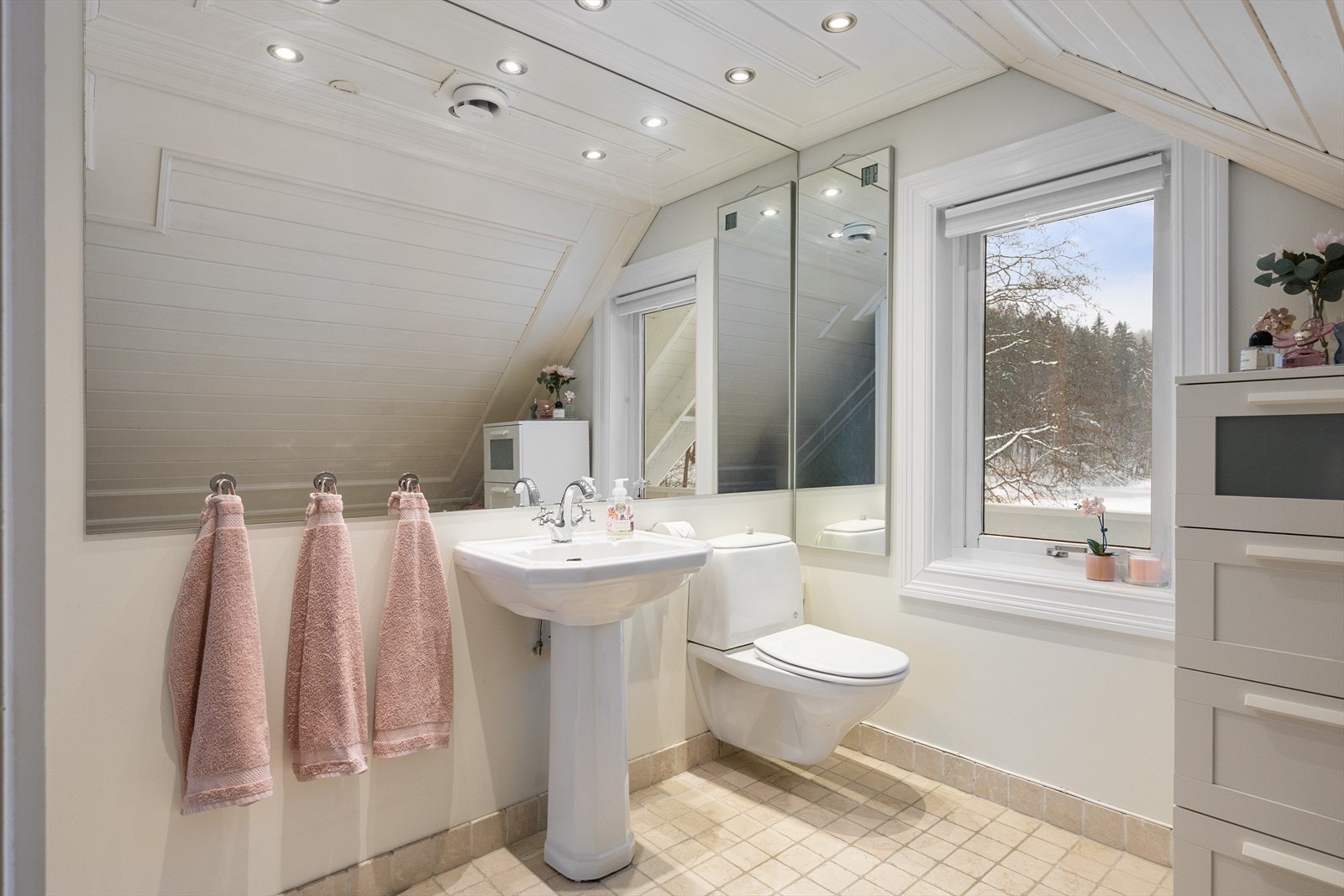 Badet er utstyrt med elektriske varmekabler. Innredningen består av vegghengt toalett med utenpåliggende sisterne, servant med speil og belysning, samt badekar. Galleribilde