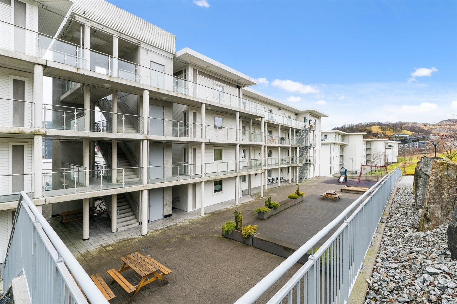 Felles opparbeidet tomt med gjesteparkering, lekeplasser og sosial sone for sameiet. Galleribilde